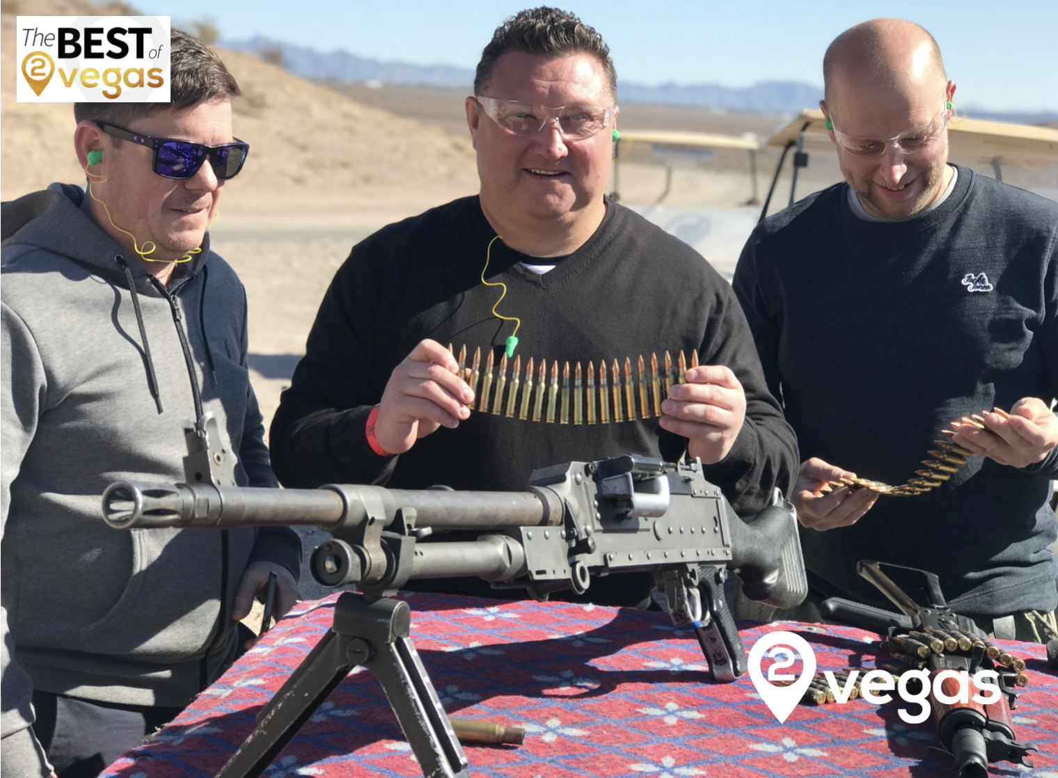 Guests handling a belt of M60 ammunition at the range